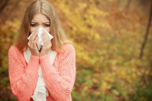 Sick Ill Woman In Autumn Park Sneezing In Tissue.